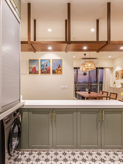 The open kitchen overlooks the dining and living areas, making it a central part of the home. A wooden rafter detail on the ceiling helps define the kitchen space while adding a rustic, textural element that complements the home's traditional aesthetic.