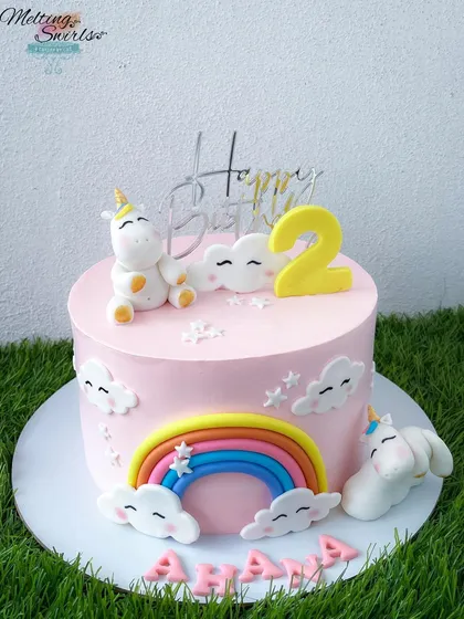 Another adorable unicorn cake, this one featuring two cute unicorns and a rainbow. The soft pink whipped cream frosting makes it a sweet and gentle design for a second birthday.
