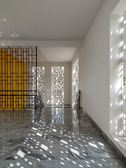 At Vidyashilp Academy, I used large, jali-inspired facade panels to filter sunlight and create a dynamic play of light and shadow. This passive design strategy not only ensures constant airflow and reduces heat but also turns a simple corridor into an ever-changing canvas of patterns.