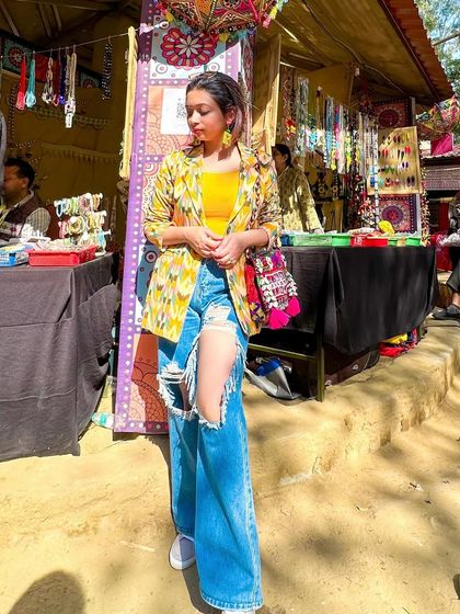 An experimental fusion look for a day at the mela. I combined an Ikat blazer with heavily ripped jeans, a bright yellow top, and sneakers. It's a mix of Indo-Western, fusion, and dopamine dressing all in one.