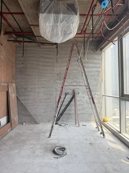 Another raw space at the 'Project LH' site. The ladder and exposed wiring are signs of a work in progress, a space filled with potential before the final layers of finishing are applied.