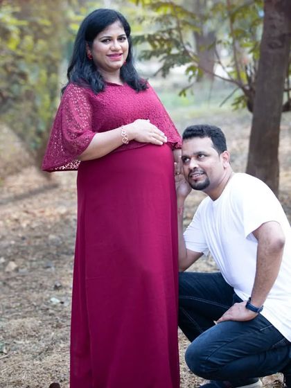 A happy father-to-be leans in to listen to his wife's belly. These simple, candid moments are often the most cherished from a maternity session.
