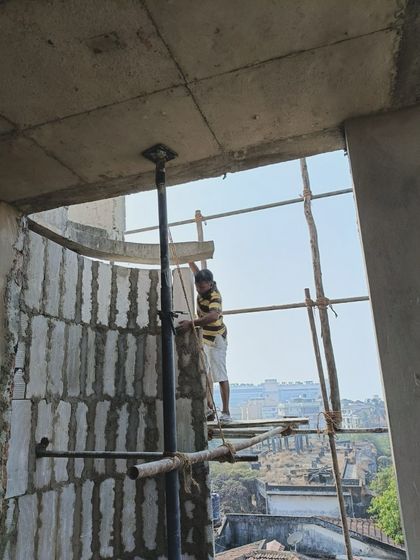 A worker constructing the blockwork for the curved walls of The Nest. This image provides a glimpse into the construction process, showing how the building's organic form is carefully built on site.