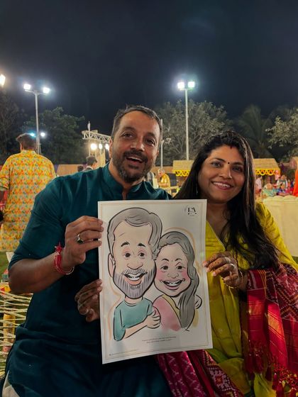 A happy couple holding their caricature at an outdoor evening event. My setup is versatile for both indoor and outdoor venues.