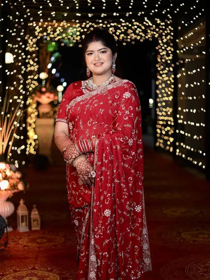 A full-length shot showing off her beautiful red reception saree and the glowing, radiant makeup. She looks absolutely stunning and ready to celebrate.