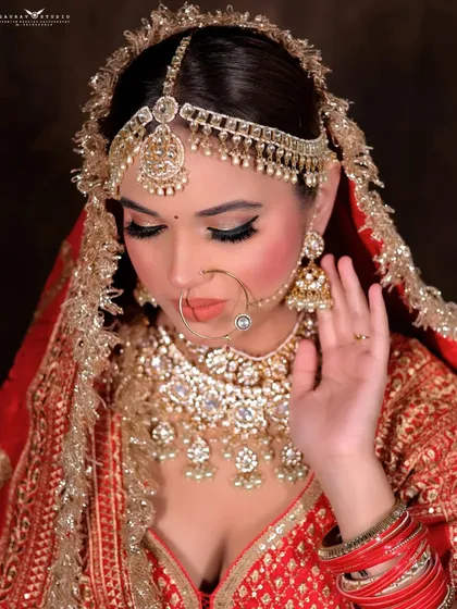 A close-up portrait with the bride's eyes lowered, focusing on the makeup and matha patti.