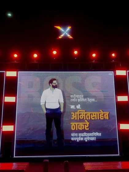 A powerful stage setup for a political event celebrating Amit Thackeray's birthday. It features a central large LED screen flanked by two vertical LED panels, creating a visually dominant and impressive display.