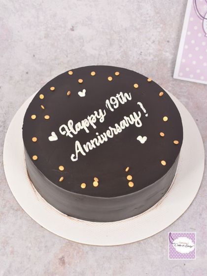 A simple chocolate anniversary cake with clean, hand-piped lettering.