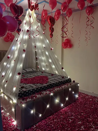 The combination of balloons, lights, and petals makes for an unforgettable romantic gesture.