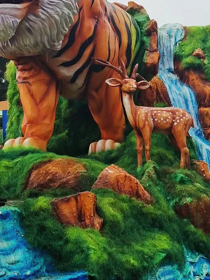 I love bringing the power of nature to life. This large-scale sculpture shows a tiger and a deer by a waterfall, all carved and painted to look as realistic as possible. It's a great example of how I create dynamic wildlife scenes for exhibitions and events.