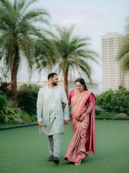 A lovely shot of a couple during their engagement shoot. The bride wears a beautiful pink saree with soft, natural makeup perfect for an outdoor setting.