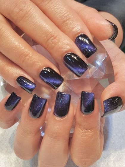 Stunning cat-eye nails in a deep, galactic purple. The magnetic polish creates a beautiful, shimmering effect that looks like a nebula on your fingertips.