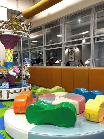 The centerpiece of our play area is this beautiful carousel, a favorite for so many children. It's surrounded by soft, colorful seating and is right next to the main play gym, making it a hub of fun.