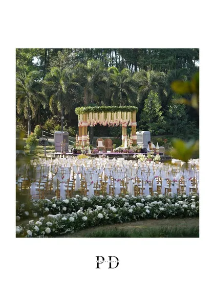 A picture-perfect view of the wedding mandap from across the lake, framed by lush greenery. This showcases how we integrate our designs into the natural beauty of the venue.