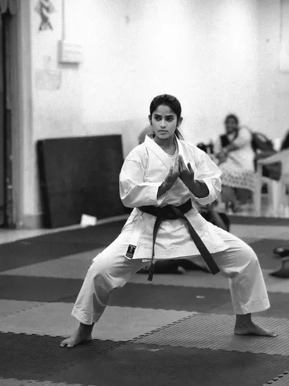 A black and white portrait capturing the focus of a student performing her kata. The intensity in her eyes shows her deep connection to the martial art.