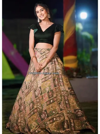 A full view of a modern and chic rental lehenga. The combination of a simple black velvet blouse with a contemporary printed skirt makes a sophisticated statement at any party.