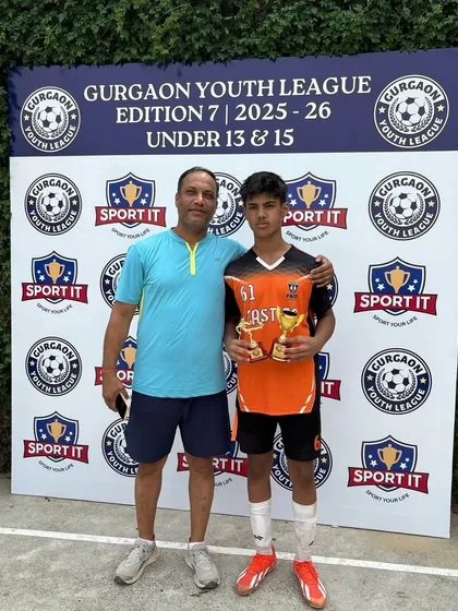 A proud moment for our U13 Best Striker, Rajveer Singh, posing with his father and his awards.
