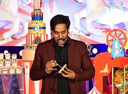 Performing a close-up trick on stage during a circus themed birthday party. Even in a big setting, I like to bring the magic up close and make it personal.