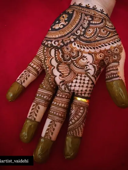 A simple yet elegant design on the back of the hand. The pattern focuses on the fingers and a central motif, leaving the rest of the hand open.