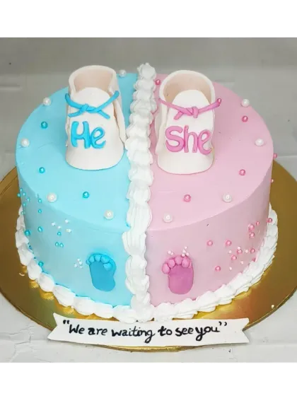 A "He or She" baby shower cake with a fresh mango flavor. This design features cute fondant baby shoes in blue and pink.