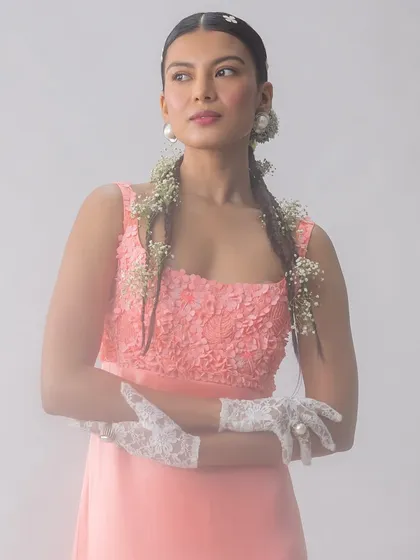 A portrait from a soft and ethereal fashion story. The styling focuses on texture, from the floral-appliqué top to the delicate lace gloves, creating a look that is both romantic and strong, framed by a dreamy, misty backdrop.