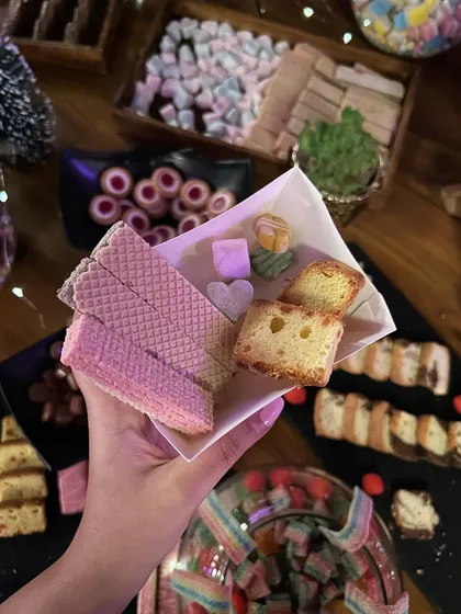 A guest's hand picking out some treats from the candy table. I love creating interactive food experiences that get everyone involved.