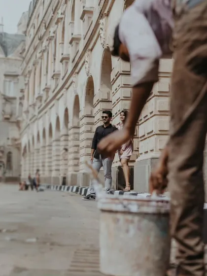 A unique street photography perspective, capturing the couple walking through Mumbai's historic Fort area, with the city's daily life adding an authentic layer to their story.