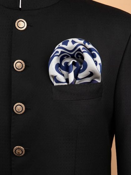 The blue and white tile-patterned pocket square folded into a jacket pocket.
