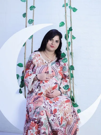 A classic solo portrait on the moon swing. This prop is one of our most requested and provides a whimsical, celestial theme for your maternity shoot.
