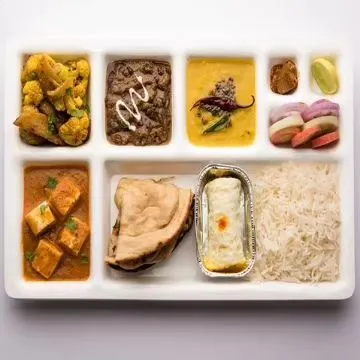 A complete and balanced North Indian thali, one of our popular options for daily corporate meals. This platter includes paneer curry, dal makhani, seasonal vegetables, roti, rice, and a dessert, offering a wholesome and satisfying lunch.