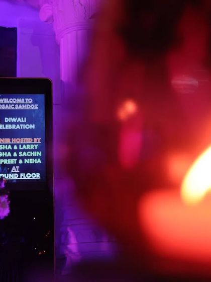 A welcome sign for the Diwali celebration, with a candle in the foreground. This shot creates a warm and inviting feeling, setting the tone for the event.
