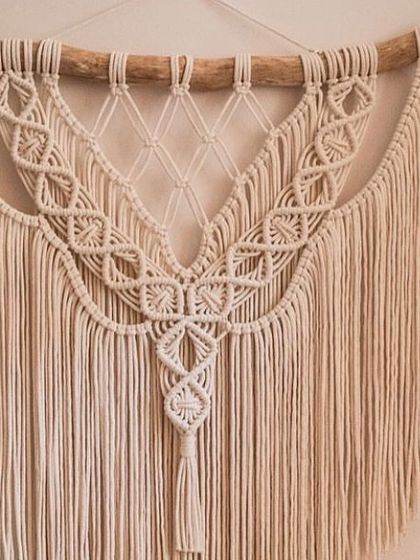 This is another one of my large, classic off-white macrame tapestries. The detailed knot work in the center creates a beautiful pattern that draws your eye in. It's mounted on a natural wooden branch for a rustic touch.