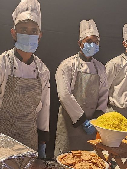 My kitchen team, masked and in uniform, ready to serve at a live counter. I prioritize hygiene and safety in all my operations, ensuring your guests can enjoy their food with complete peace of mind.