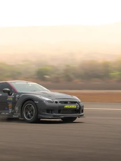 This action shot captures a heavily modified Nissan GTR as it kicks up dust, showcasing its power and track-focused modifications.