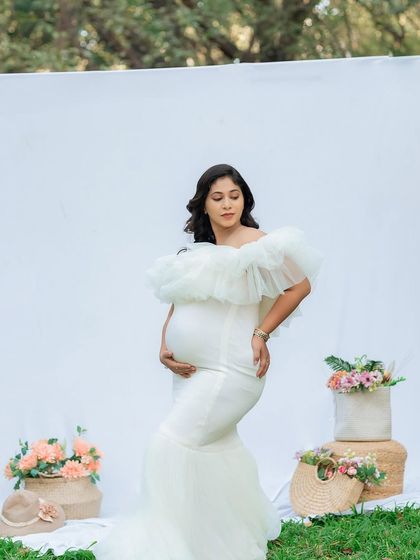 A standing portrait that beautifully showcases the baby bump. The soft, natural lighting of this outdoor session highlights the classic silhouette of motherhood.