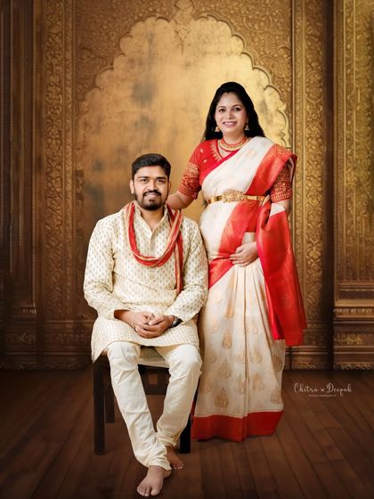 A regal and formal portrait against a palatial gold backdrop. The couple's traditional attire makes them look like royalty.