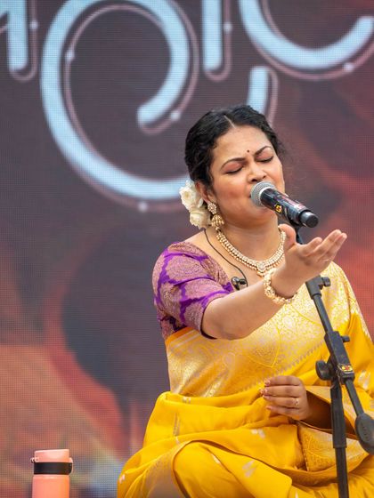 A powerful performance shot of Priyanka Barve, where the rich colors of her saree and the stage lighting create a magical effect.