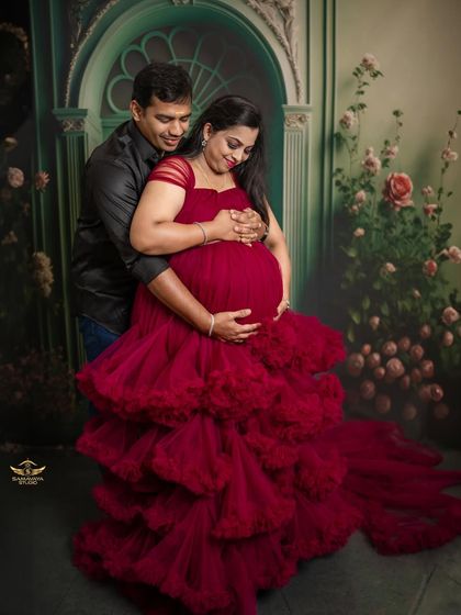 A loving embrace from the partner, surrounding the mother and baby bump. A beautiful portrait of family and protection.