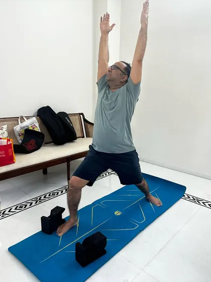 Virabhadrasana I (Warrior I). A powerful standing pose that builds strength and confidence, modified to be accessible for someone with gout.