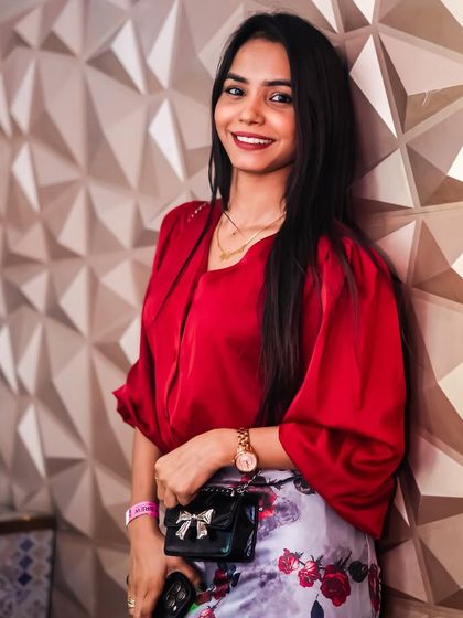A guest in a stylish red top against the club's signature wall.