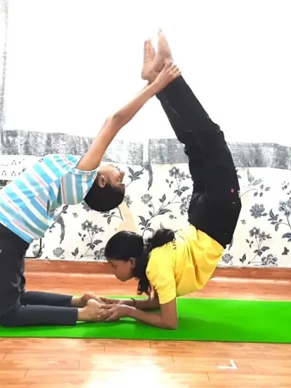 A creative partner pose combining the Camel and Tiger poses. This acro yoga formation requires one partner to hold a deep backbend while the other performs an inversion, showcasing both flexibility and strength.