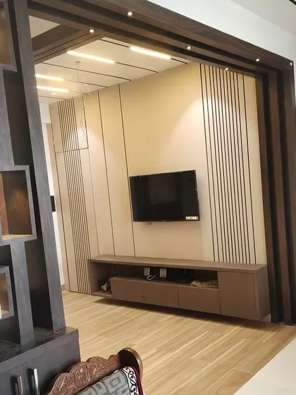 Another perspective of the TV unit installation, highlighting the ceiling track lighting and the wooden frame that will define the space.