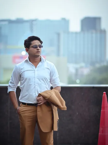 A slightly different take on the "jacket over the shoulder" pose. The composition here is focused on the subject's confident stance and the clean lines of his outfit.