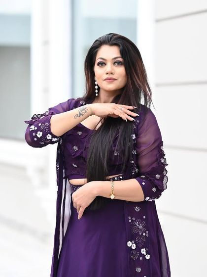 A graceful pose that highlights the flowy jacket and the model's elegant hand gestures.