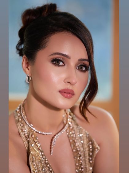 The client looks absolutely radiant. The soft, romantic updo complements her glowing makeup and diamond jewelry, creating a truly show-stopping look for her special night.