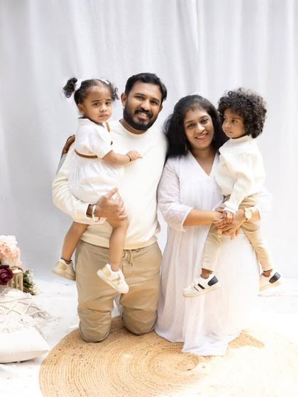 A classic outdoor family portrait. The family stands together, smiling, creating a beautiful and timeless memory in a natural setting.