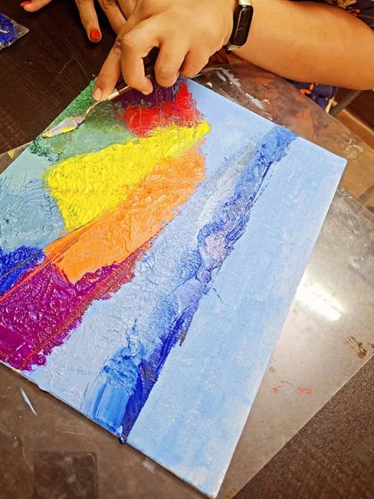 The initial layers of an abstract landscape being built up with a palette knife. It's all about trusting the process and letting the colors flow.