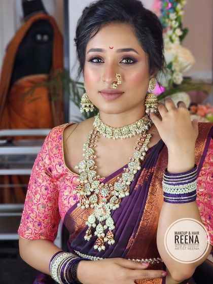 A full view of the traditional Marathi look. The purple Paithani saree with a pink blouse, combined with heavy jewellery, creates a stunning effect.