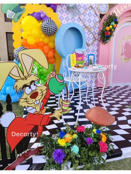 The March Hare pours tea at a whimsical photo station.