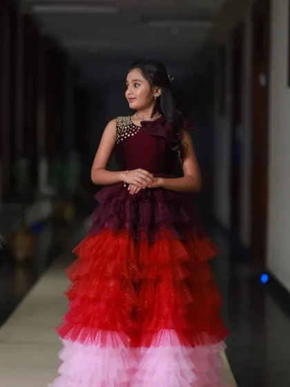 I designed this multi-layered gown with shades of wine, red, and pink for a special 10th birthday party. The bodice features delicate beadwork for an extra touch of sparkle.